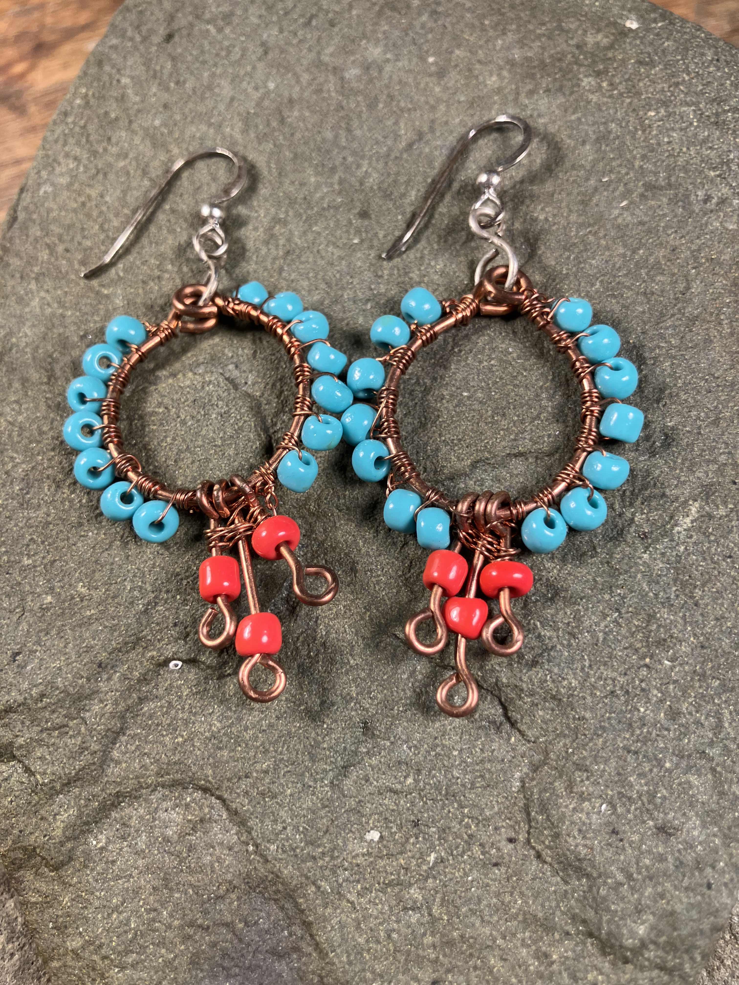 earring hoop of blue-green beats with red-orange dangles