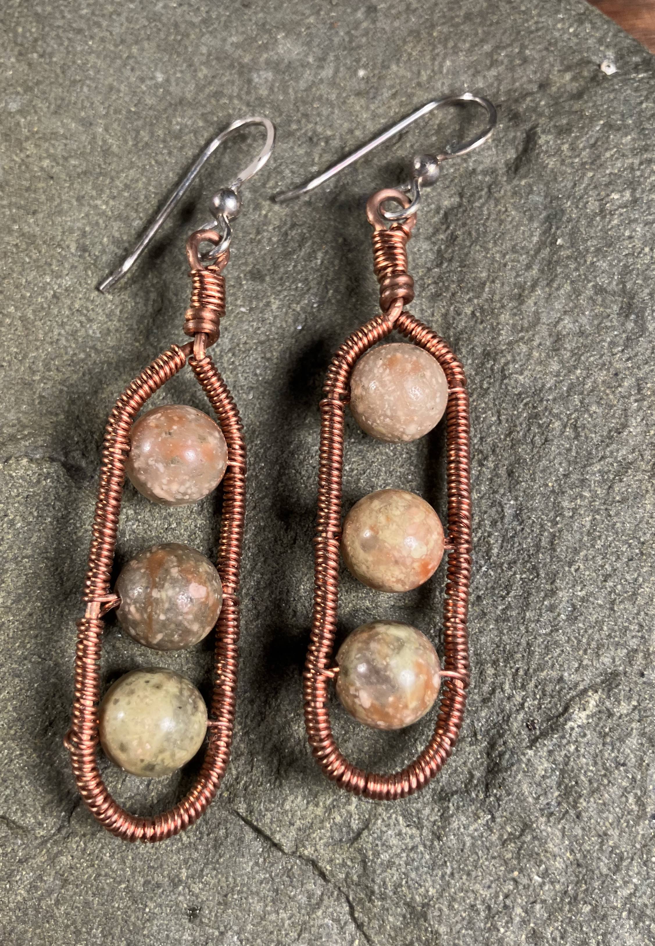 copper wire wrapped earrings with cartouche shape and 3 round sun stones